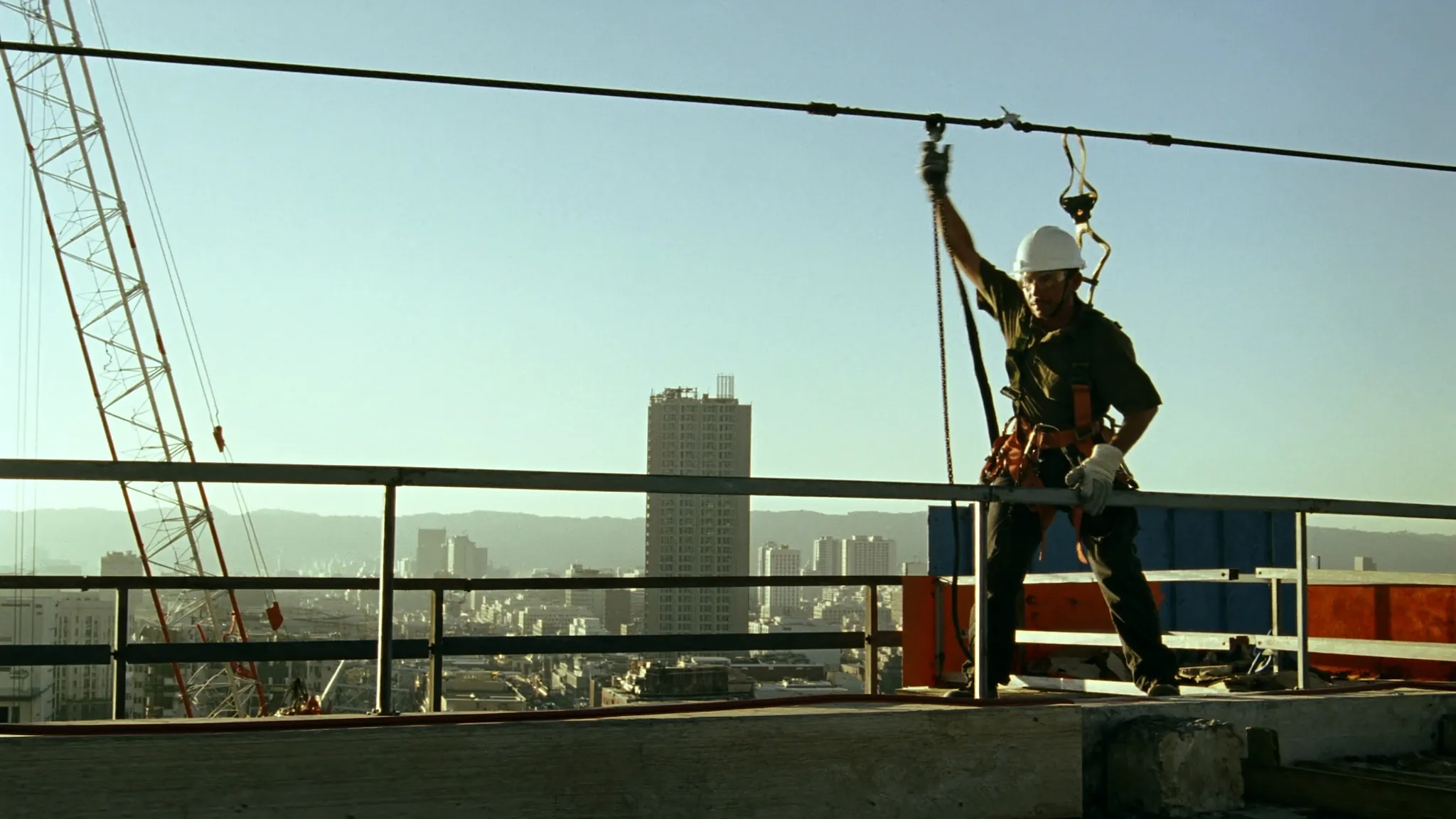 Trabajador con arnés conectado a una línea de vida horizontal en el borde protegido de una losa en construcción